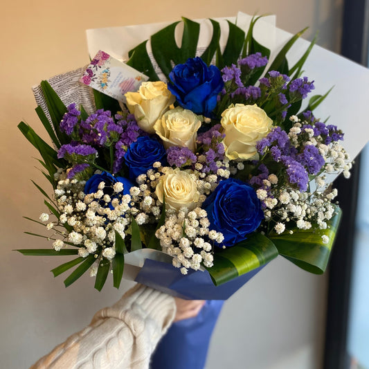 Blue Sky Bouquet with 8 white and blue roses, baby's breath, delphinium, and eucalyptus, beautifully arranged in a serene, elegant design.