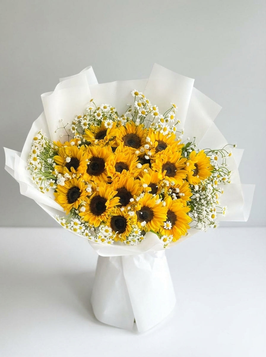 Bouquet of yellow sunflowers with white paper wrapping on a light gray background