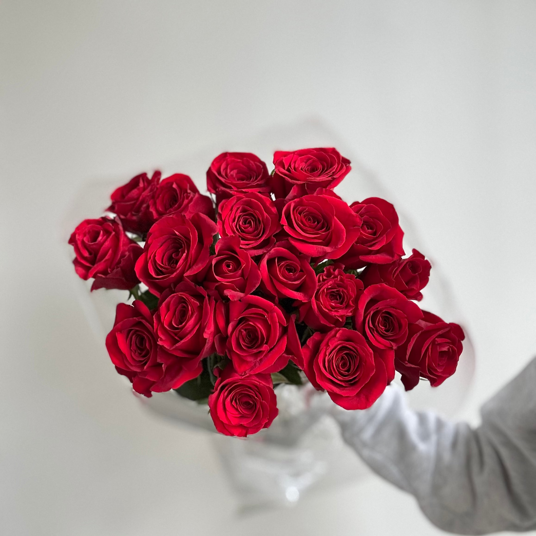 Bouquet of red roses in a clear vase on a white background
