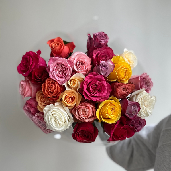 Bouquet of multicolored roses on a light gray background