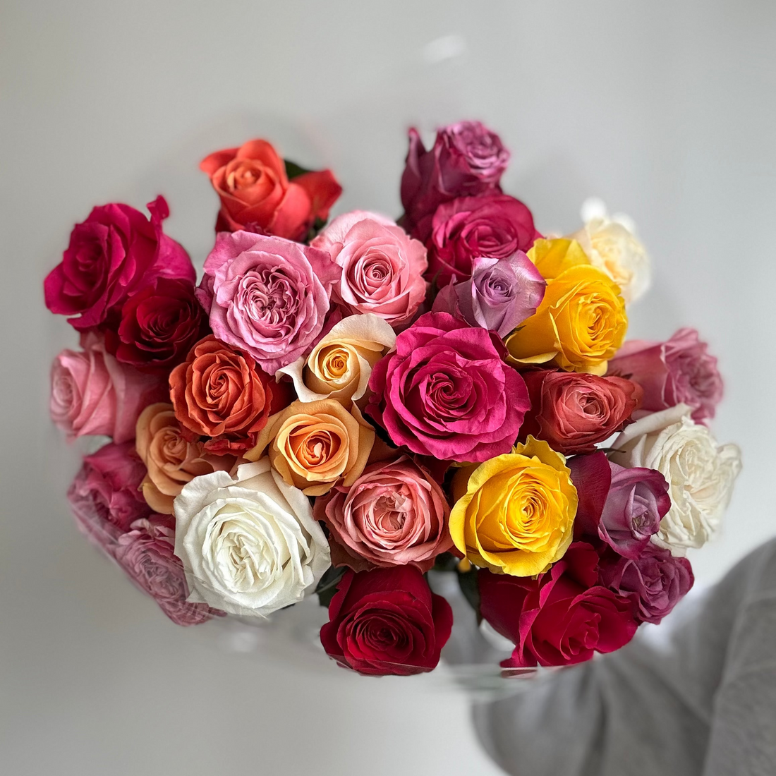 Bouquet of multicolored roses on a light gray background