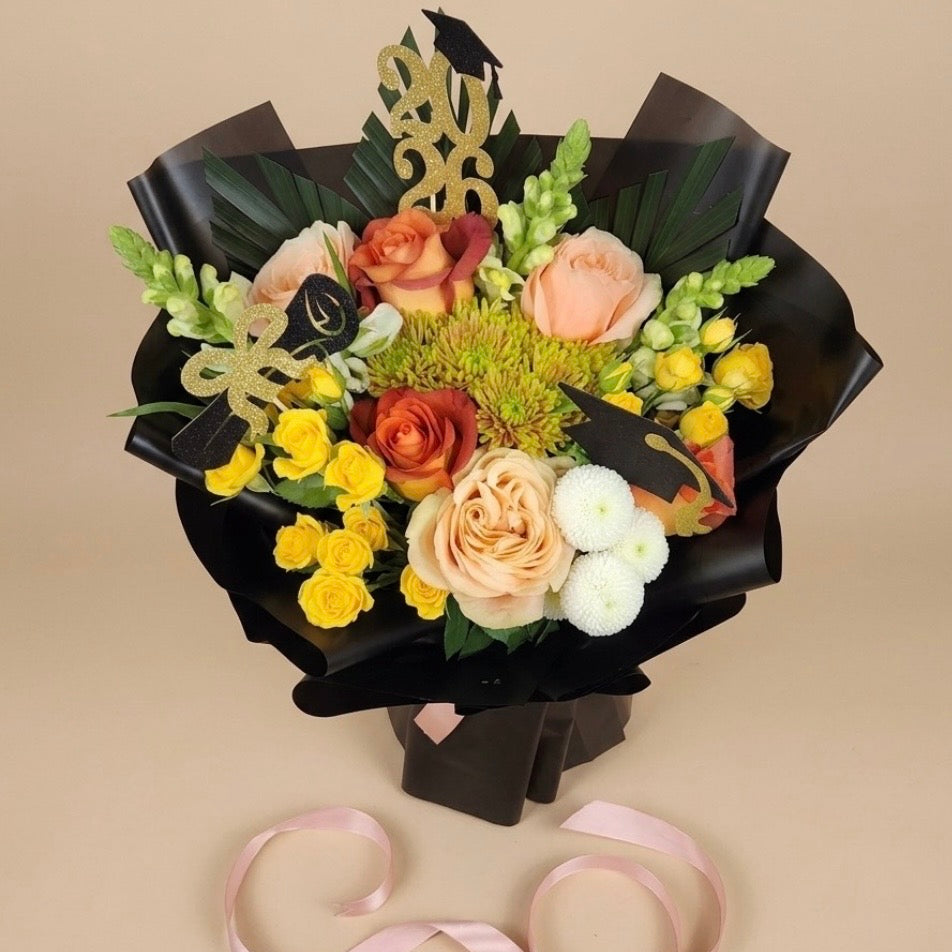 Bouquet of flowers in a black box with a decorative ribbon on a beige background