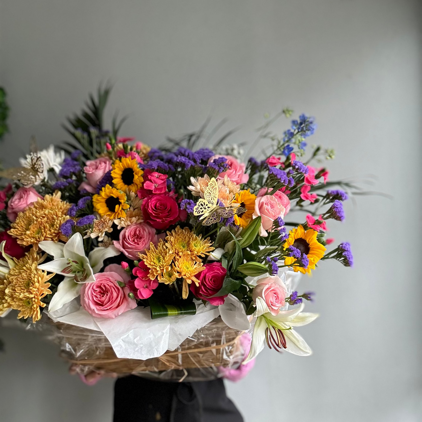 Bouquet of colorful flowers held against a plain background