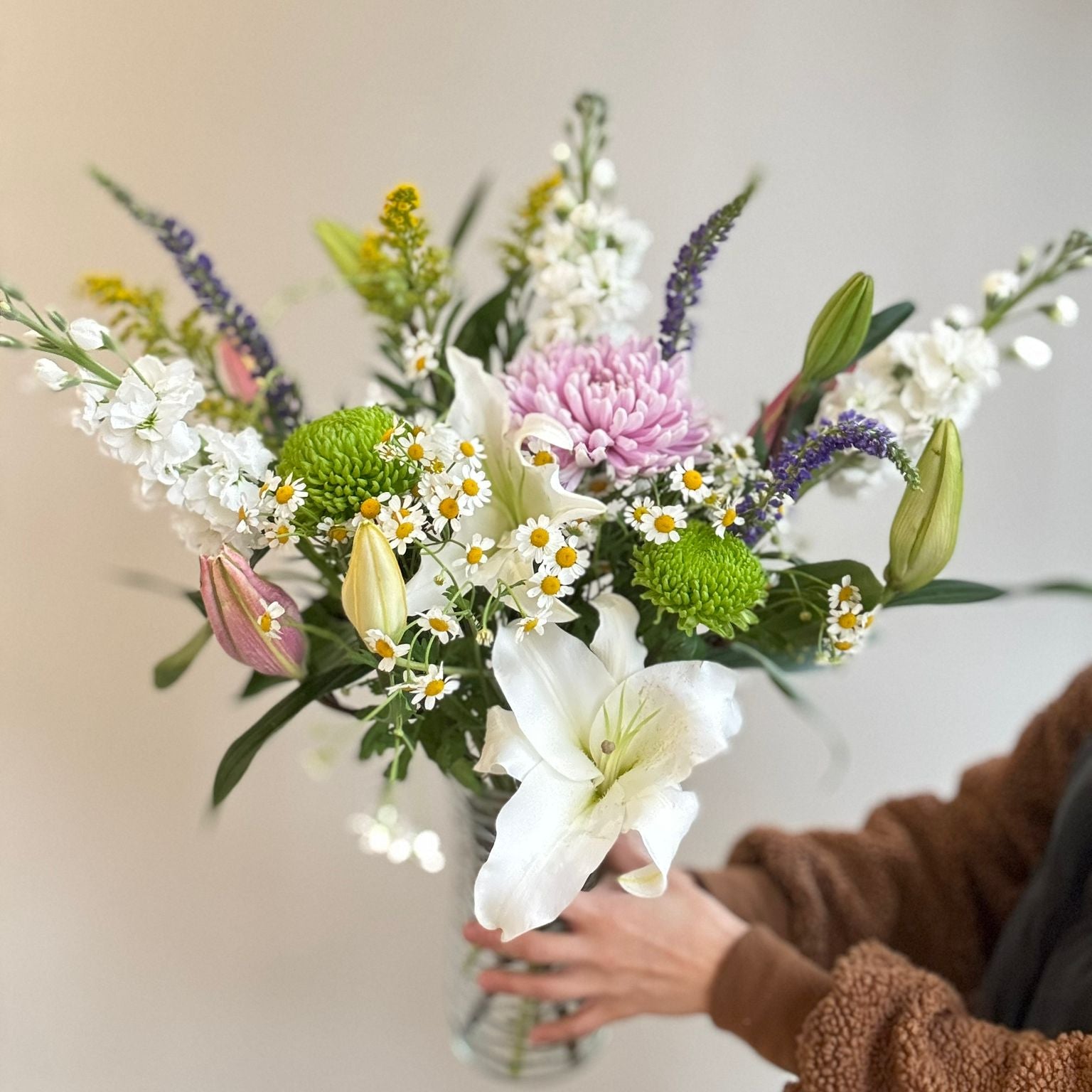Bouquet of flowers held by a person with a blurred background