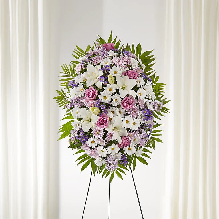 Floral arrangement on a stand against a white curtain background