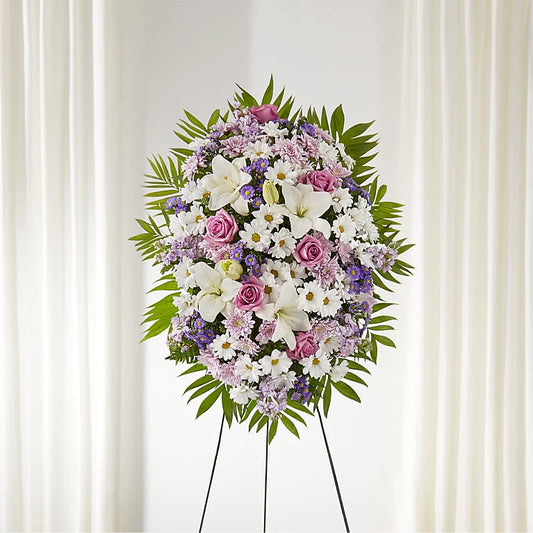 Floral arrangement on a stand against a white curtain background