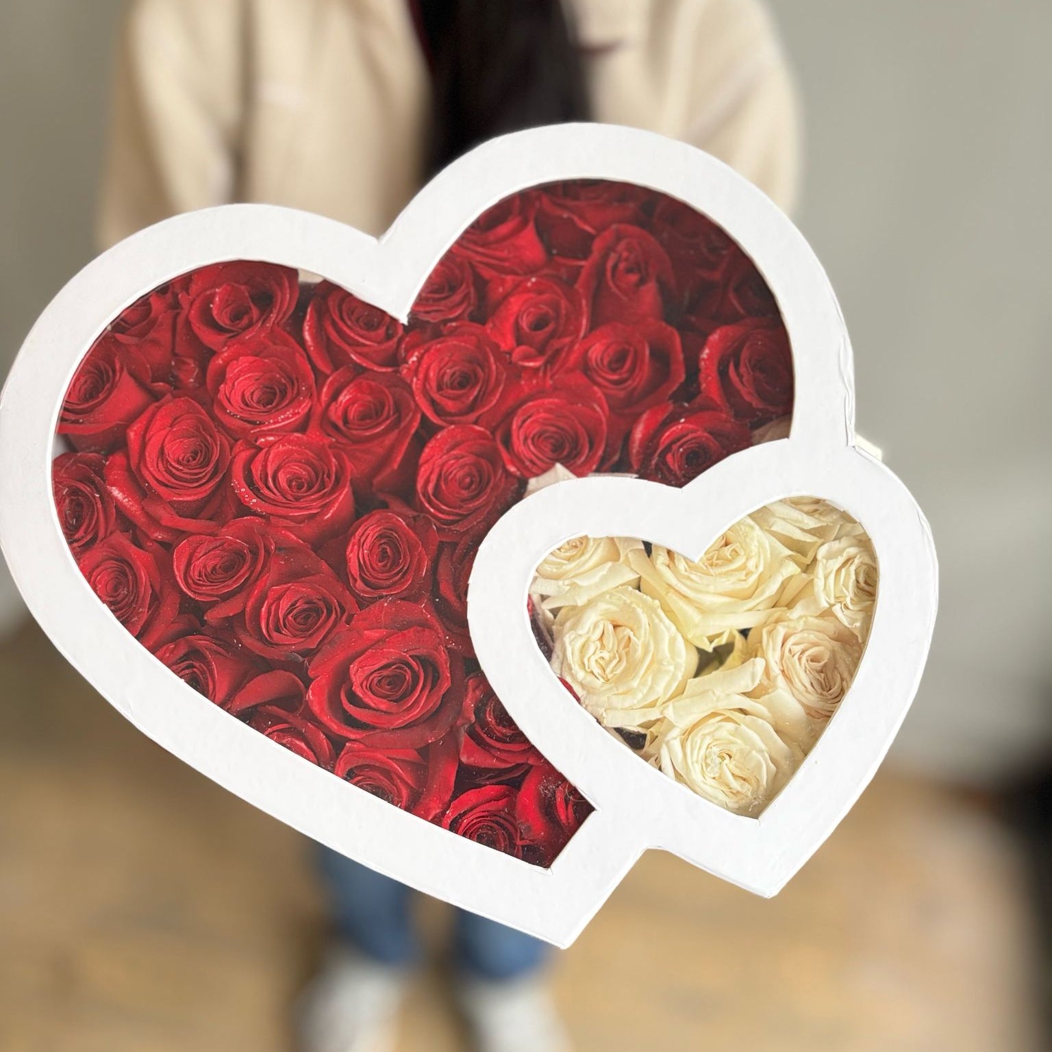 Heart-shaped box with red and white roses on a blurred background