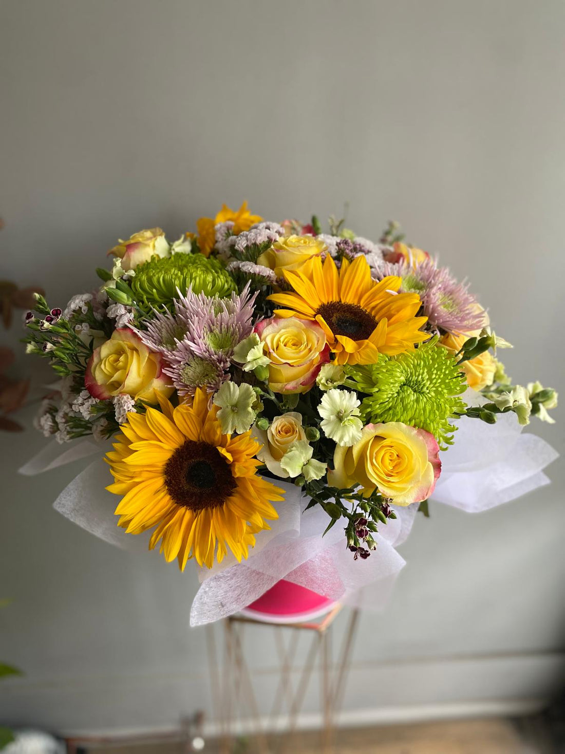 Bouquet of flowers with sunflowers and roses on a gray background