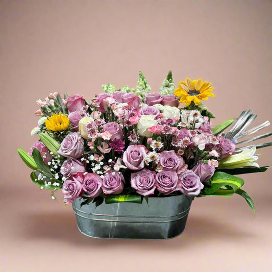 Fairy Basket, whimsical mix of pastel roses, lilies, sunflowers, and fresh filler flowers.