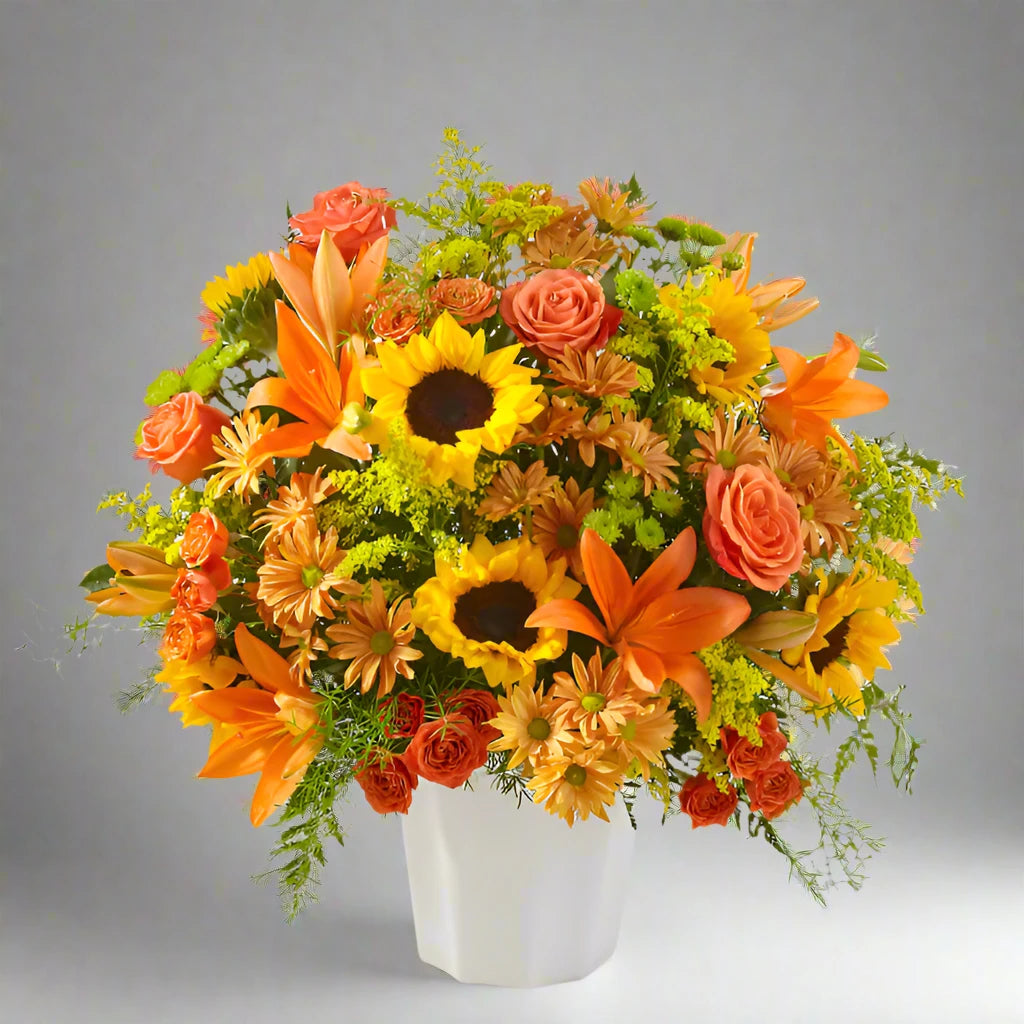  A vibrant funeral floor basket featuring a mix of orange-toned flowers, including sunflowers, marigolds, and other complementary blooms. The arrangement is designed in a large, elegant basket, offering a warm and uplifting tribute to a loved one. Perfect for memorial services or celebrating a life.



