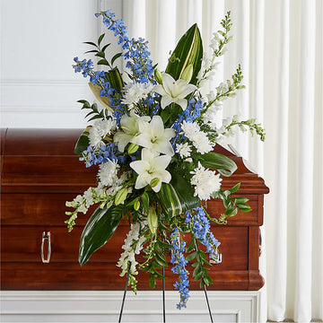 Elegant funeral wreath with fresh white lilies, roses, and greenery arranged in a classic circular design, symbolizing eternal love and remembrance. A beautiful floral tribute for honouring and celebrating the life of a loved one.