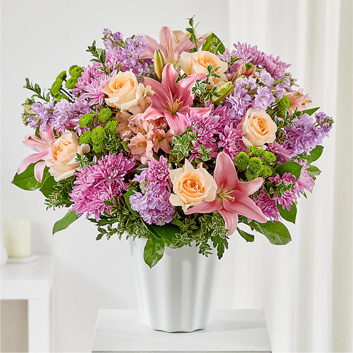 Supportive Embrace Tabletop Basket with a mix of pink flowers and greenery in a woven basket for sympathy or funeral occasions."