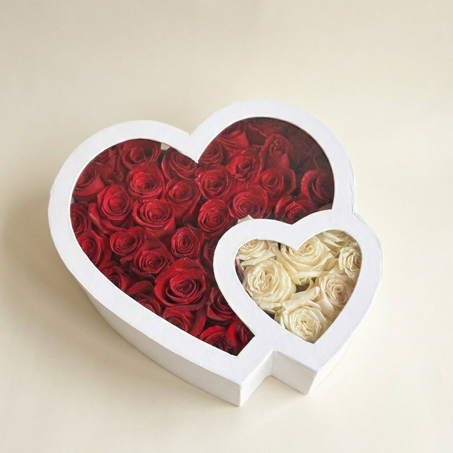 Heart-shaped box with red and white roses on a beige background