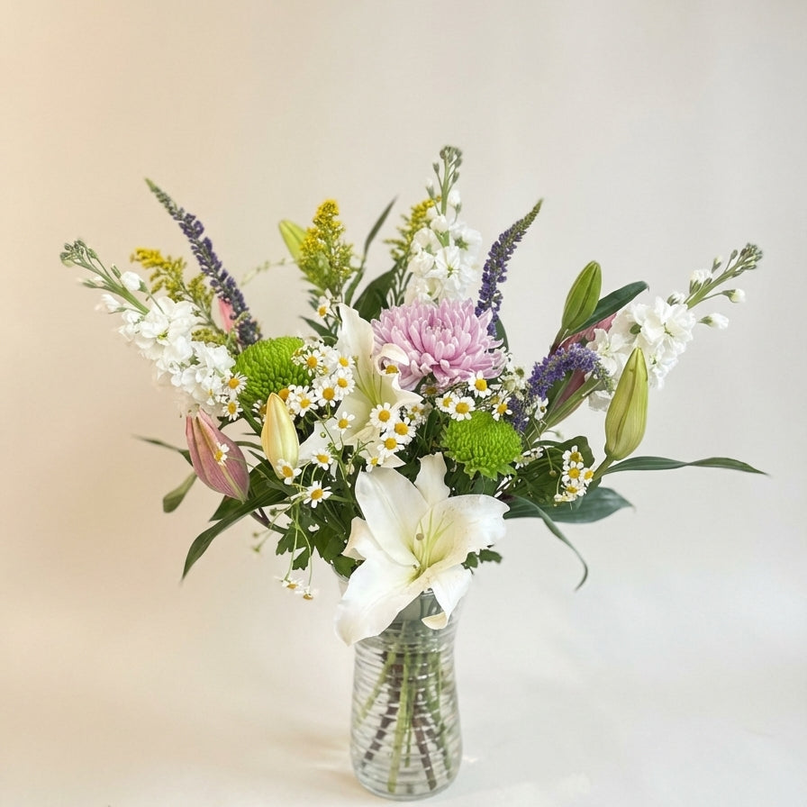 Bouquet of flowers in a clear vase on a light background