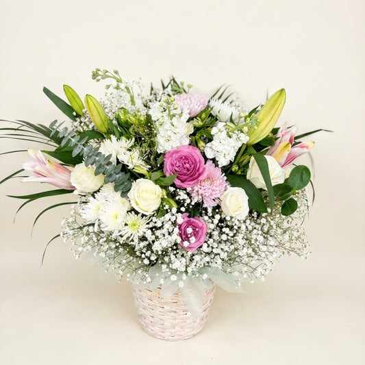Bouquet of flowers in a basket on a light background