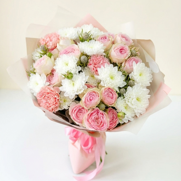 Bouquet of pink and white flowers wrapped in brown paper on a light background
