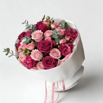 Bouquet of pink and purple roses in a white box on a light gray background