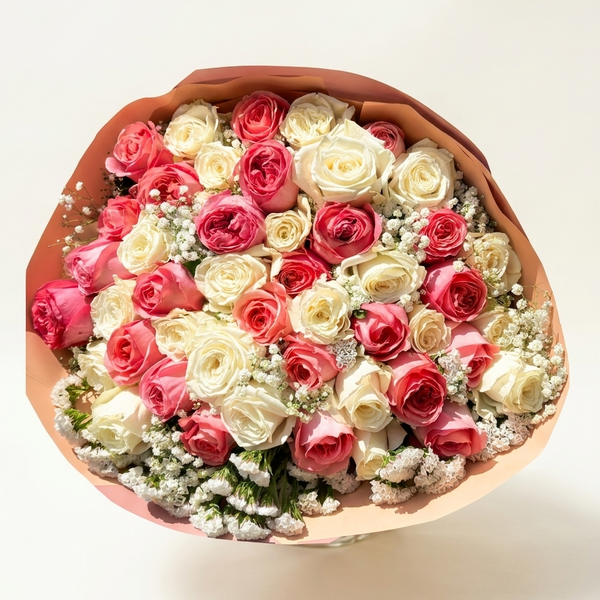 Heart-shaped bouquet of pink and white roses on a light background