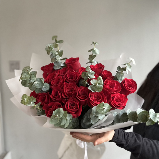 A vibrant and striking bouquet featuring bold red roses, orange marigolds, and fiery accents, arranged in a dynamic display resembling the colors and intensity of flames