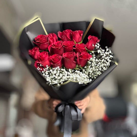 A romantic bouquet of deep red roses, elegantly arranged to symbolize love and passion. The bouquet features rich, velvety petals and lush greenery, making it the perfect gift for anniversaries, Valentine's Day, or to express deep affection.