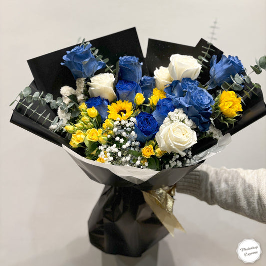 Starry Night-inspired bouquet featuring vibrant blue delphiniums, yellow sunflowers, white lilies, and purple irises, designed to reflect the bold colors and swirling energy of van Gogh's iconic painting. Perfect for art lovers and special occasions